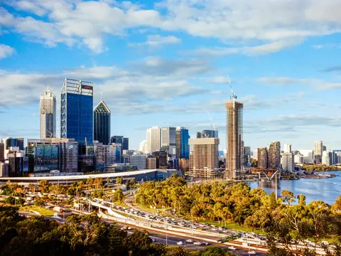The Perth city skyline and the Swan River seen from Kings Park, with the freeway and park trees below